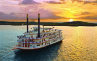 View of Branson lake and boat at sunset: best Branson travel bloggers