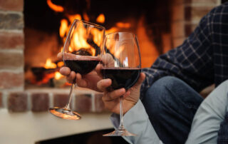 couple having glass of wine in front of a fireplace, activities in Branson for couples