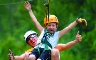 Father and son riding Branson ziplines through the Ozarks